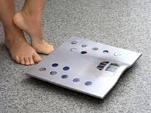 Woman's feet next to metal scale